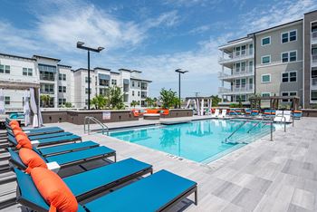 Sparkling resort style pool with lounge chairs to soak up the sun